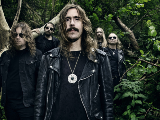 All members of Opeth pictured amongst trees and other foliage