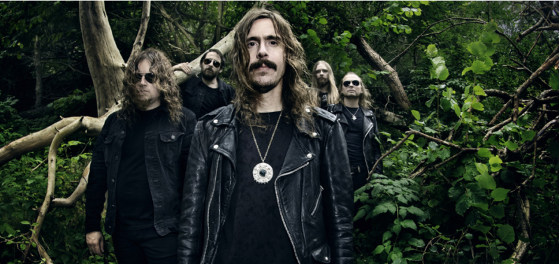 All members of Opeth pictured amongst trees and other foliage