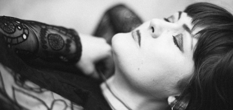 Singer-songwriter Austel pictured lying down with her eyes closed, in black and white